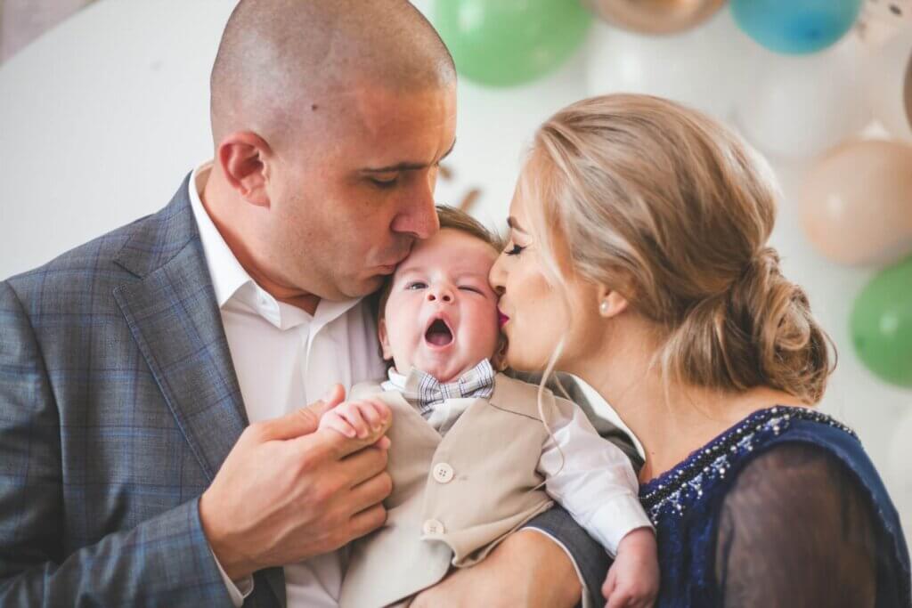 子どもを囲んでパパとママがキスをする、温かい家族婚の幸せなワンシーン