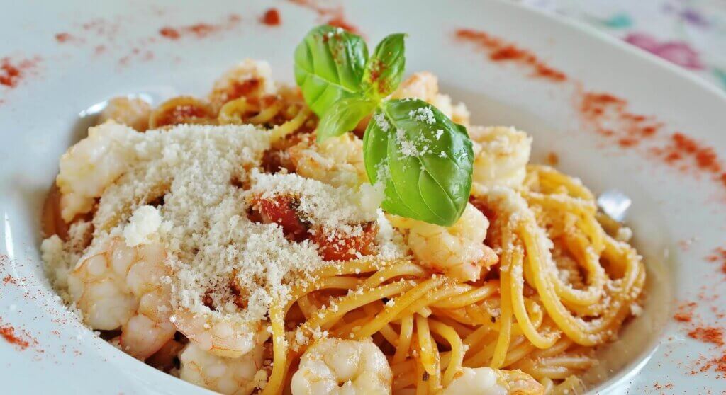 エビとトマトソースのパスタにパルメザンチーズとバジルを添えた一皿